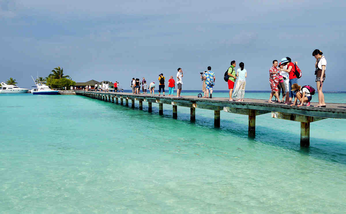 Chinese tourist walk on foot bridge over the sea in Maldives on Jan. 16, 2012. More and more Chinese tourists go to Maldives for holidays. MATATO