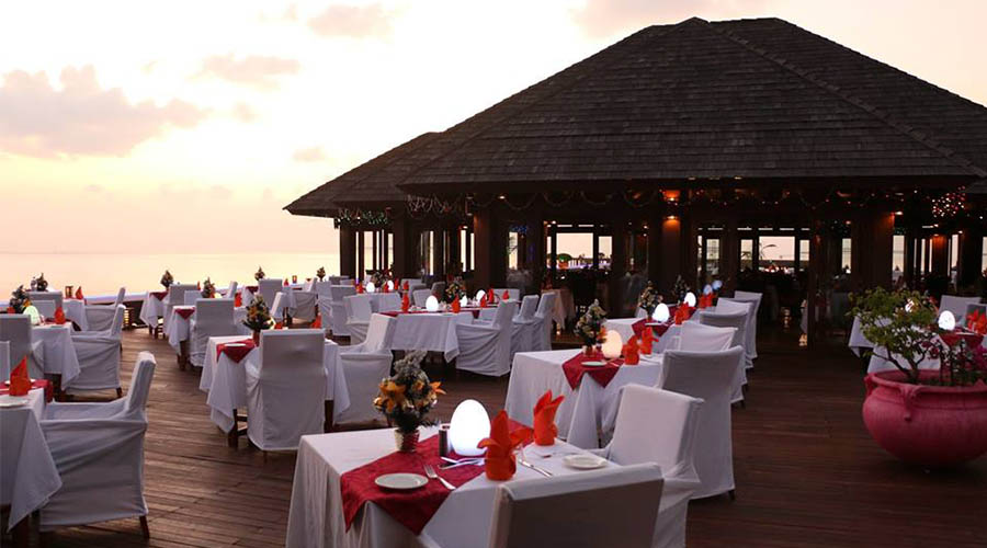 Valentines day dinner set up tables at an over water venue at sunset