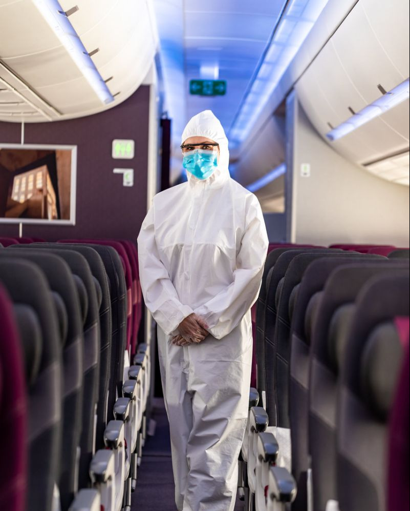 a cabin crew of Qatar Airways in full protective gear to combact the Covid virus while in inflight