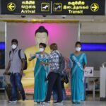 Colombo airport official with masks on directing passengers to there request
