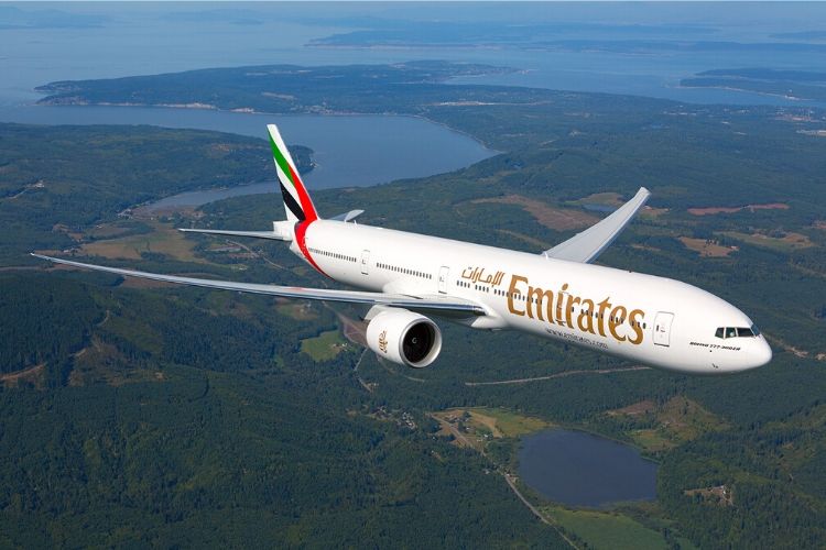 Emirates Boeing 777 aircraft flying over land. Emirate resumes operation to 29 cities post covid-19