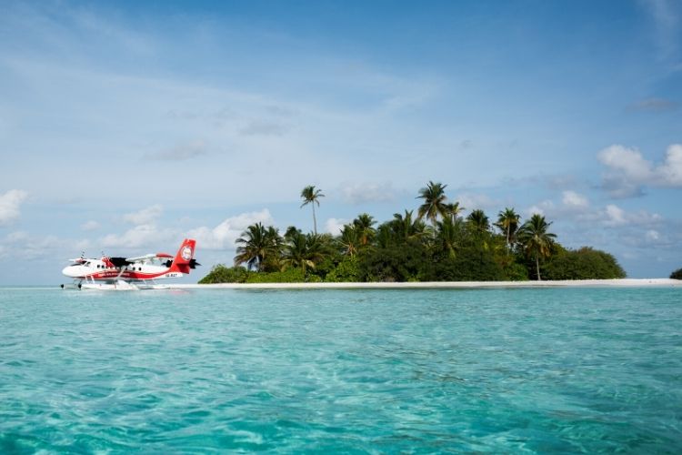 Trans Maldivian Airways aircraft in ready to take off from a turquoise lagoon in Maldives.