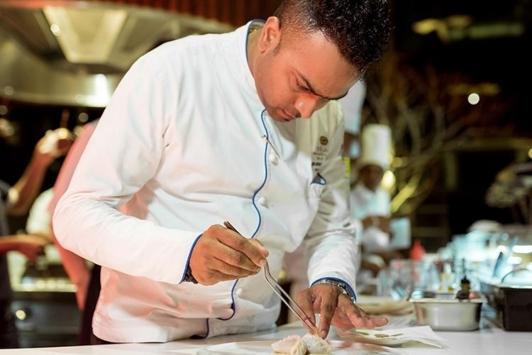Chef creating a dish at aragu restaurant in velaa private island